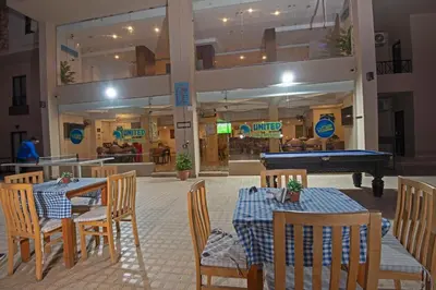 a restaurant with tables and a pool table in a building at Aqua Tropical Apartment Near El Gouna in Hurghada