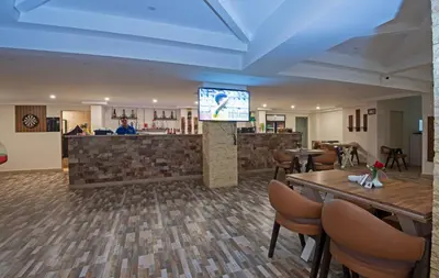 a restaurant with tables and a tv in a room at Aqua Tropical Apartment Near El Gouna in Hurghada