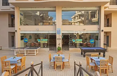 a patio with tables and ping pong tables in front of a building at Aqua Tropical Apartment Near El Gouna in Hurghada