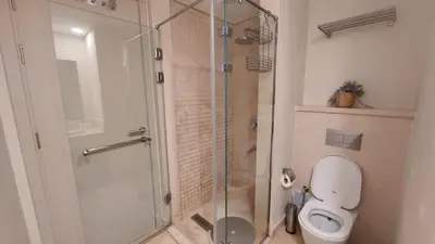 a bathroom with a toilet and a glass shower at Mangroovy Beach Front - 1 BR - Free Beach & Pool access in Hurghada
