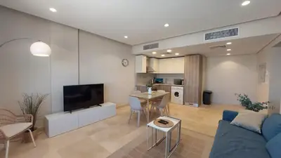 a living room with a blue couch and a kitchen at Mangroovy Beach Front - 1 BR - Free Beach & Pool access in Hurghada