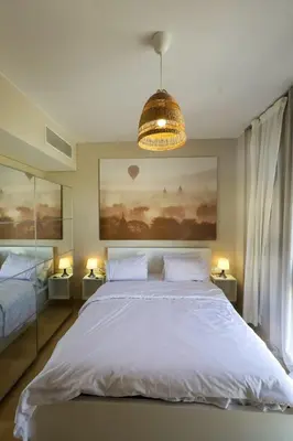 a bedroom with a large white bed and a chandelier at Mangroovy Beach Front - 1 BR - Free Beach & Pool access in Hurghada