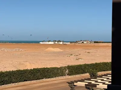 a bench in front of a beach with the ocean at El Gouna Ancient Sand Villa 3 Bedroom & Nanny in Hurghada