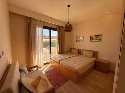 a bedroom with a bed and a couch and a window at El Gouna Ancient Sand Villa 3 Bedroom & Nanny in Hurghada