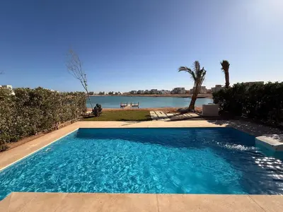 a swimming pool with a view of the water at El Gouna Ancient Sand Villa 3 Bedroom & Nanny in Hurghada