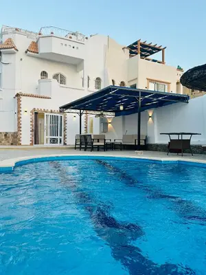 a swimming pool with blue water in front of a building at villa sky in Hurghada