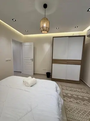 a bedroom with a large white bed and a chandelier at Karma in Hurghada