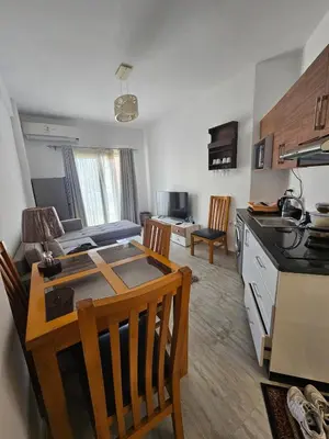 a kitchen and living room with a table and chairs at Aqua palms resort 2 bed flat C409 in Hurghada