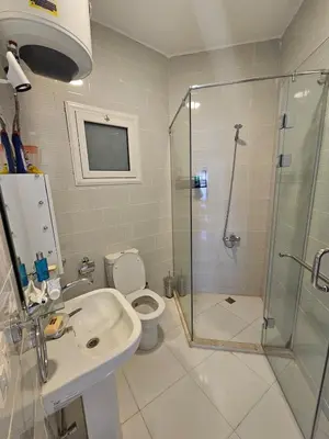 a bathroom with a shower and a toilet and a sink at Aqua palms resort 2 bed flat C409 in Hurghada