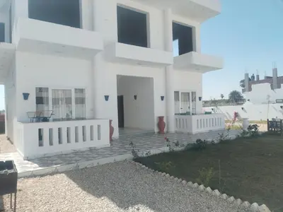 a large white house with a yard at Luxor heaven apartment in Luxor