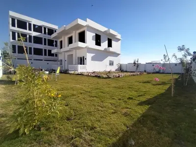 a white building with a grassy yard in front of it at Luxor heaven apartment in Luxor