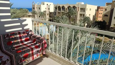 a chair on a balcony with a view of a resort at شاليه فندقى in Hurghada