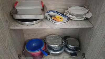 a refrigerator shelf with dishes and a sink and plates at شاليه فندقى in Hurghada