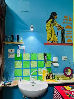 a bathroom with a sink and a woman painted on the wall at Marwa House an Authentic Mud-Brick Home in Al Aqālitah