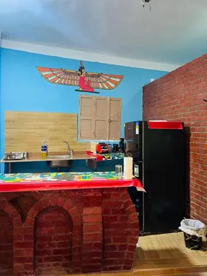 a kitchen with a brick counter with an eagle on the wall at Marwa House an Authentic Mud-Brick Home in Al Aqālitah