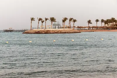 a body of water with palm trees and a beach at Mirage Bay Resort Hurghada C-781 in Hurghada