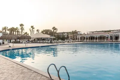 a large swimming pool with a resort in the background at Mirage Bay Resort Hurghada A-775 in Hurghada