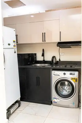 a kitchen with a washing machine and a refrigerator at Mirage Bay Resort Hurghada C-775 in Hurghada