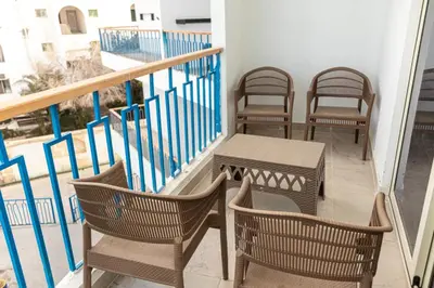 a balcony with chairs and a table on a balcony at Mirage Bay Resort Hurghada C797 in Hurghada
