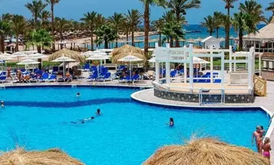 a pool at a resort with blue chairs and umbrellas at Mirage Bay Resort Hurghada C797 in Hurghada