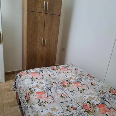 a bed with a quilt on it in a room at Julia's Guest House in Shellal