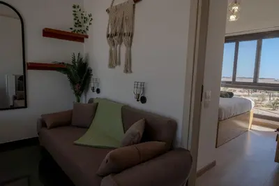 a living room with a couch and a bedroom at Signature Kamaran duplex 1 bed pool & views in Hurghada