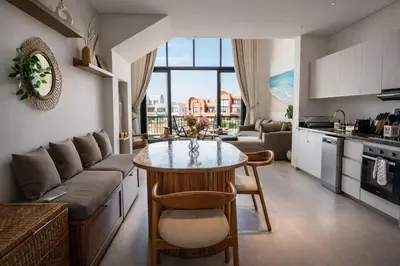 a kitchen and living room with a table and a couch at Signature Kamaran duplex 1 bed pool & views in Hurghada