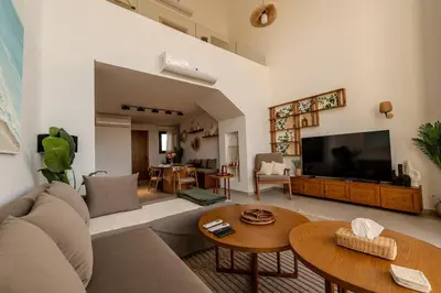 a living room with a couch and a flat screen tv at Signature Kamaran duplex 1 bed pool & views in Hurghada