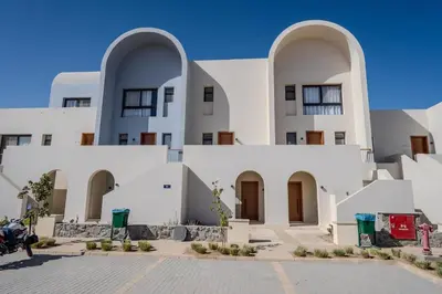 a large white building with three arched windows at Signature Kamaran duplex 1 bed pool & views in Hurghada