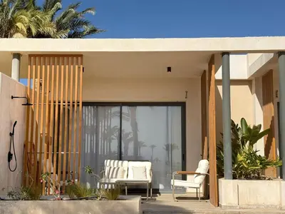 a house with two chairs on a patio at Pool front Mesca Cabana Minutes to Sandy Beach in Soma bay in Hurghada