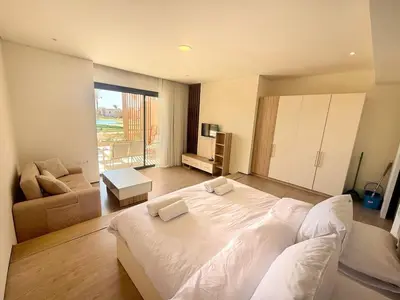 a bedroom with a large white bed and a couch at Pool front Mesca Cabana Minutes to Sandy Beach in Soma bay in Hurghada