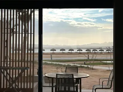 a patio with a table and chairs and umbrellas at Beachfront Cabana Steps to Sandy Beach And Pool in Soma bay in Hurghada