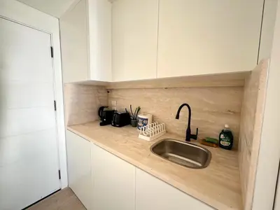 a kitchen with a sink and white cabinets at Beachfront Cabana Steps to Sandy Beach And Pool in Soma bay in Hurghada