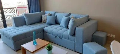 a blue couch in a living room with a table at 1 br stylish flat in phase 2 MH in Hurghada