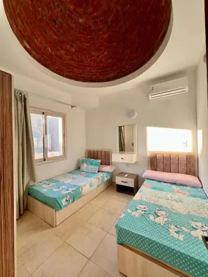 a bedroom with two beds and a circular ceiling at 2 bedroom flat with balcony in Hurghada