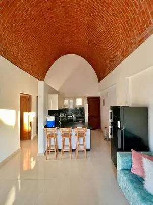 a kitchen with a couch and a table with chairs at 2 bedroom flat with balcony in Hurghada