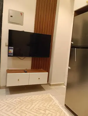 a living room with a flat screen tv on a wall at Karma Apartment in Hurghada