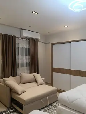 a living room with a couch and a screen at Karma Apartment in Hurghada