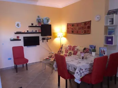 a dining room with a table and red chairs at Iris Holiday Apartament in Hurghada