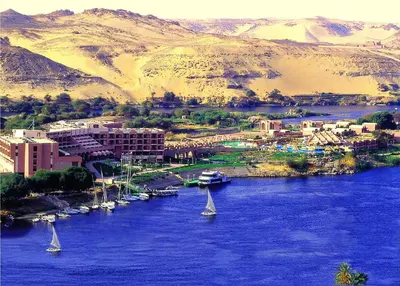a group of sailboats in a river with a city at Pyramisa Island Hotel Aswan in Aswan
