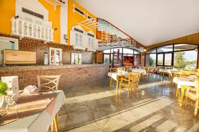 a restaurant with yellow walls and tables and chairs at Pyramisa Island Hotel Aswan in Aswan