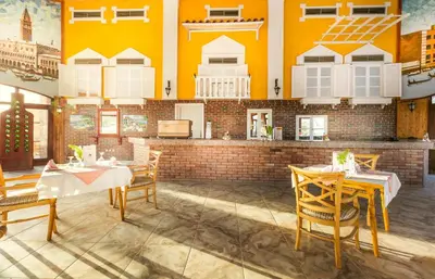 a restaurant with two tables and yellow walls at Pyramisa Island Hotel Aswan in Aswan