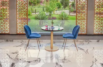two blue chairs and a table in a patio at Pyramisa Hotel Luxor in Luxor
