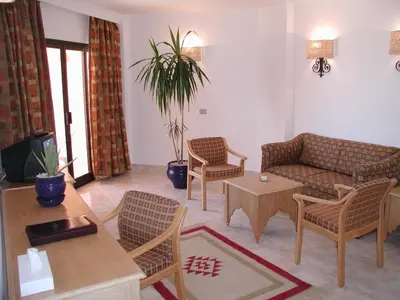 a living room with a couch and a table and chairs at Flamenco Beach & Resort Quseir in Quseir