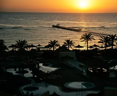 a view of the ocean and a pier at sunset at Flamenco Beach & Resort Quseir in Quseir
