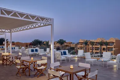 a rooftop patio with tables and chairs and buildings at JAZ Solaya in Coraya Bay