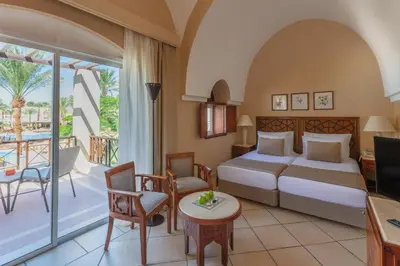 a hotel room with a bed and a balcony at Iberotel Makadi Beach in Hurghada