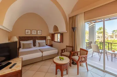 a hotel room with a bed and a balcony at Iberotel Makadi Beach in Hurghada