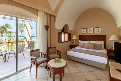 a hotel room with a bed and a balcony at Iberotel Makadi Beach in Hurghada