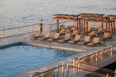 a swimming pool with lounge chairs next to the water at Iberotel Luxor in Luxor